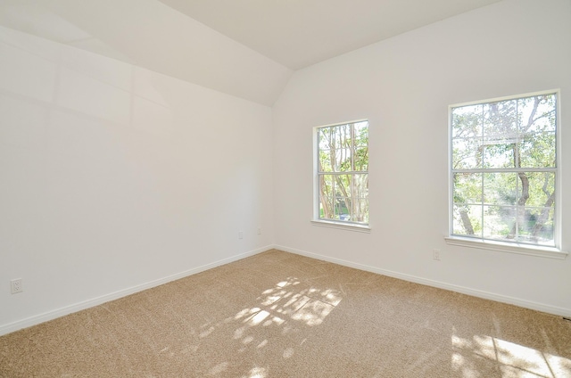 unfurnished room featuring carpet floors, vaulted ceiling, and a healthy amount of sunlight