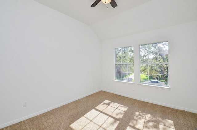 spare room featuring ceiling fan, light carpet, and vaulted ceiling