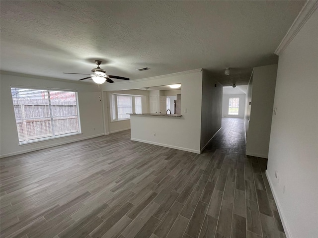 unfurnished living room featuring ceiling fan, dark hardwood / wood-style floors, crown molding, and a textured ceiling