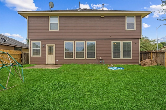 rear view of property with a lawn and a patio