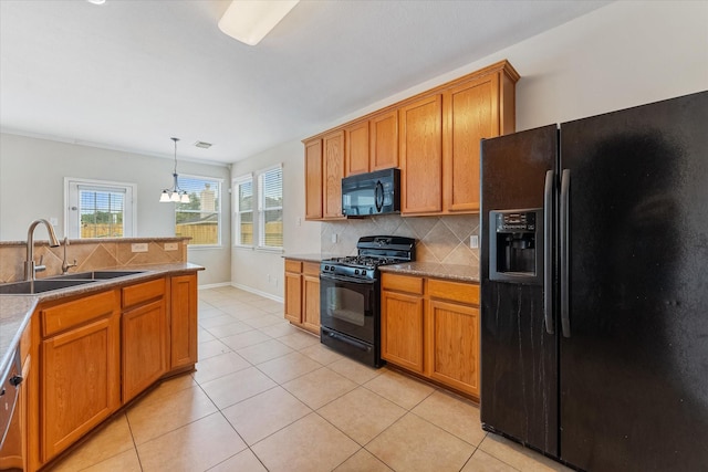 kitchen featuring decorative backsplash, sink, black appliances, an inviting chandelier, and hanging light fixtures