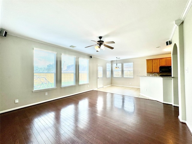 unfurnished living room featuring light hardwood / wood-style floors, ceiling fan, and ornamental molding