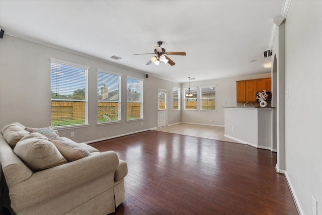 living room featuring hardwood / wood-style flooring, ceiling fan, and crown molding