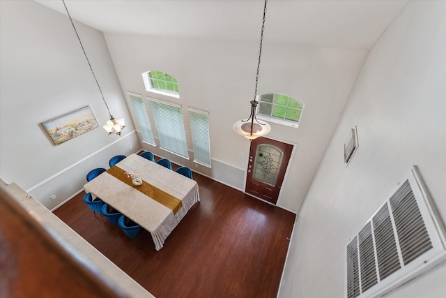 entryway featuring a notable chandelier, dark hardwood / wood-style flooring, and a towering ceiling