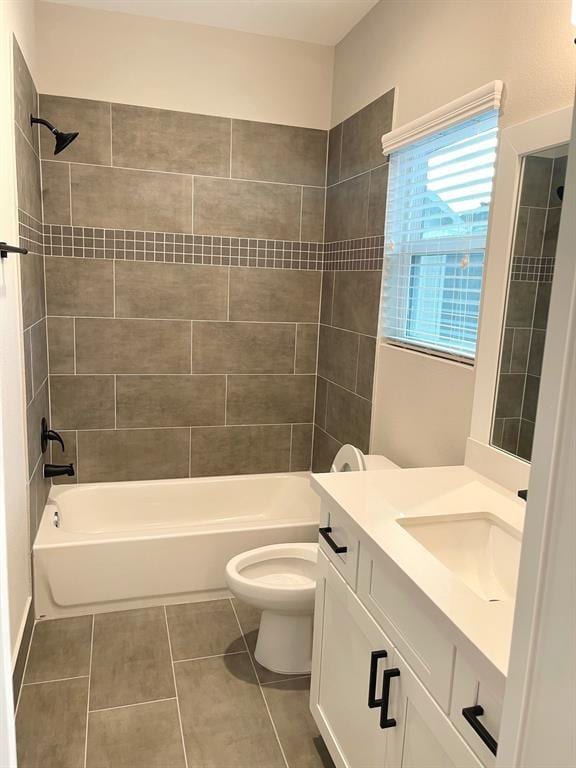 full bathroom with tile patterned flooring, vanity, toilet, and tiled shower / bath