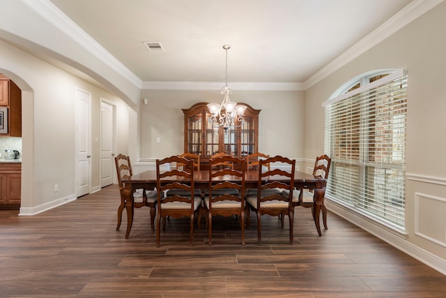 dining space featuring a notable chandelier, dark hardwood / wood-style floors, and ornamental molding