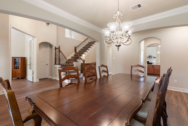 dining area featuring a notable chandelier, dark hardwood / wood-style flooring, and ornamental molding