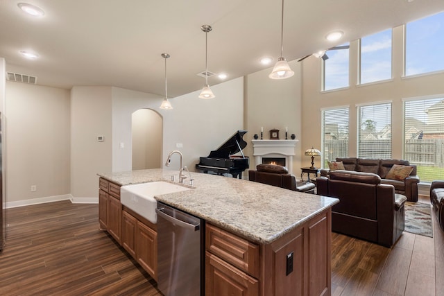 kitchen featuring dishwasher, a kitchen island with sink, sink, and decorative light fixtures