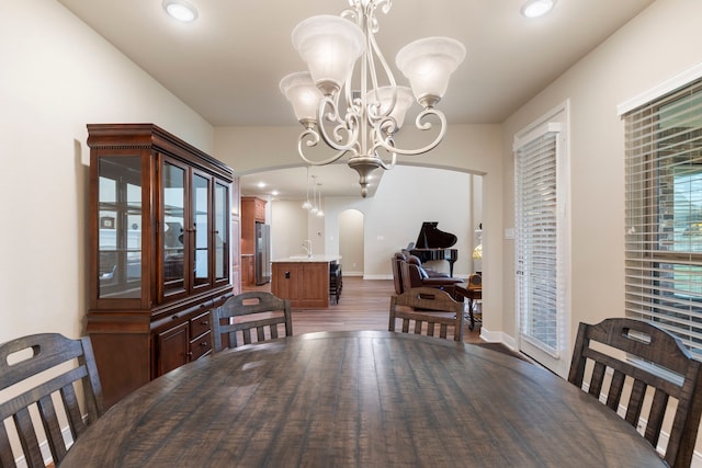 dining room with dark hardwood / wood-style flooring and a notable chandelier