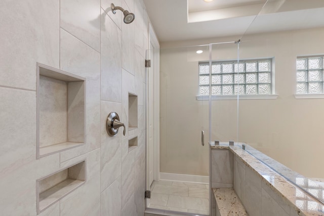 bathroom featuring a shower with door and plenty of natural light