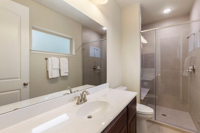 bathroom featuring vanity, a shower with shower door, and toilet