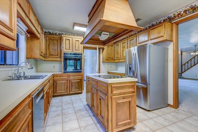 kitchen featuring sink, ceiling fan, appliances with stainless steel finishes, a kitchen island, and light colored carpet