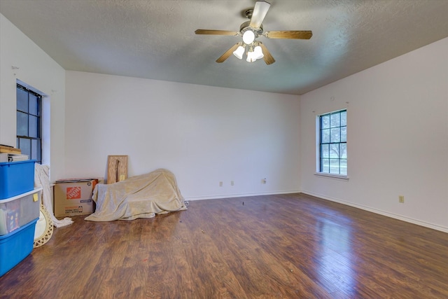 unfurnished room featuring a textured ceiling, ceiling fan, and dark wood-type flooring