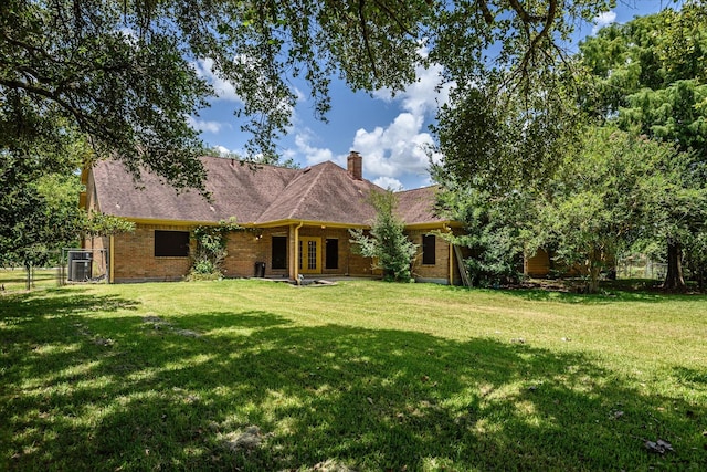 single story home featuring cooling unit and a front yard