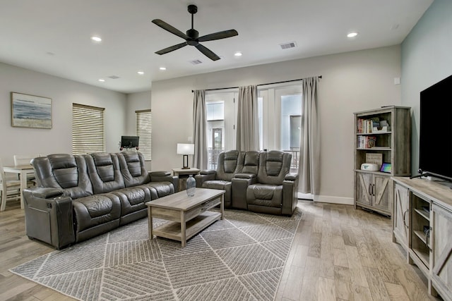 living room with ceiling fan and light hardwood / wood-style flooring