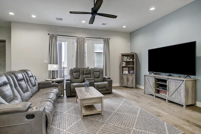 living room with ceiling fan and light hardwood / wood-style flooring