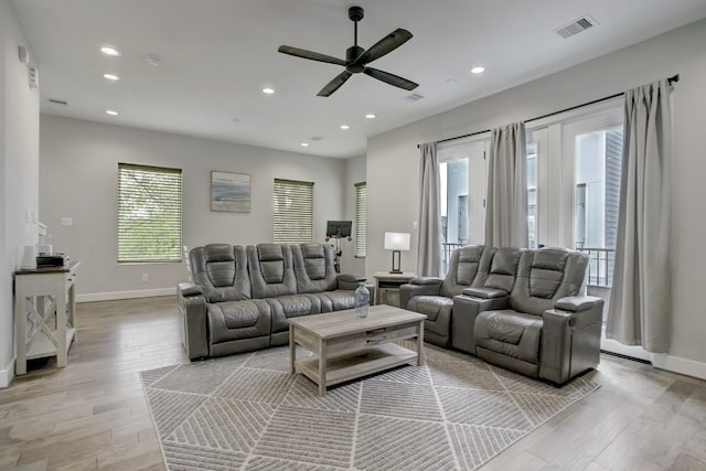 living room featuring light hardwood / wood-style flooring and ceiling fan