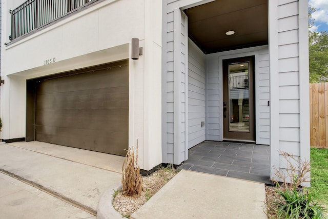 doorway to property with a garage and a balcony