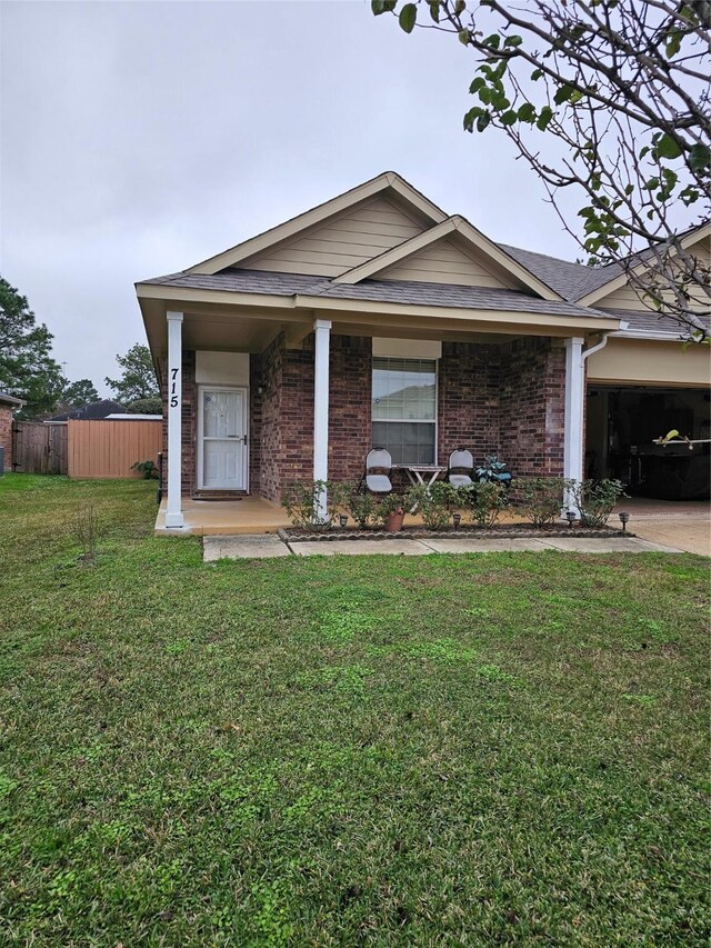 ranch-style house featuring a porch, a front yard, and a garage