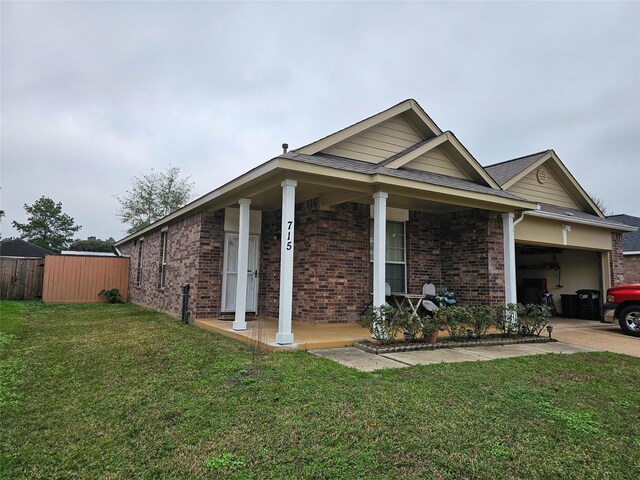 view of front of property featuring a garage, a porch, and a front yard