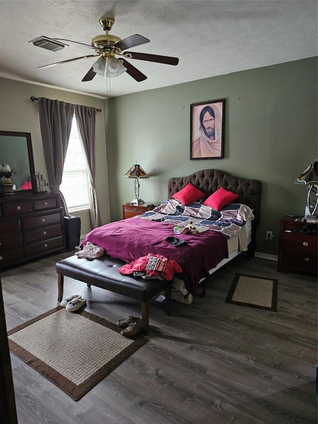 bedroom featuring hardwood / wood-style flooring, ceiling fan, and a textured ceiling