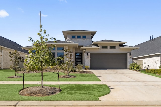 prairie-style home featuring a front lawn and a garage