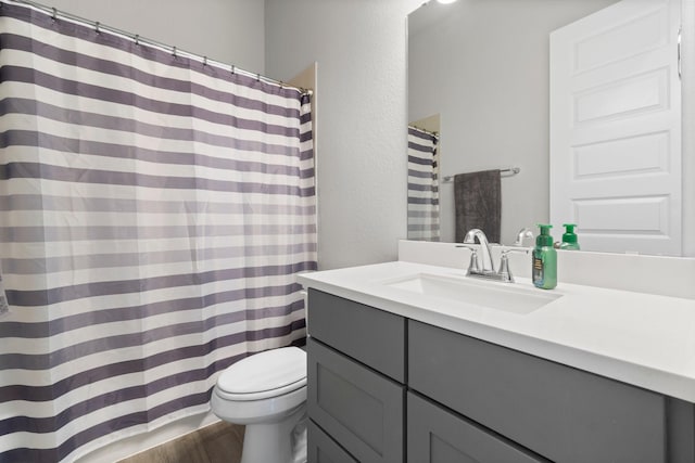 bathroom with wood-type flooring, vanity, and toilet