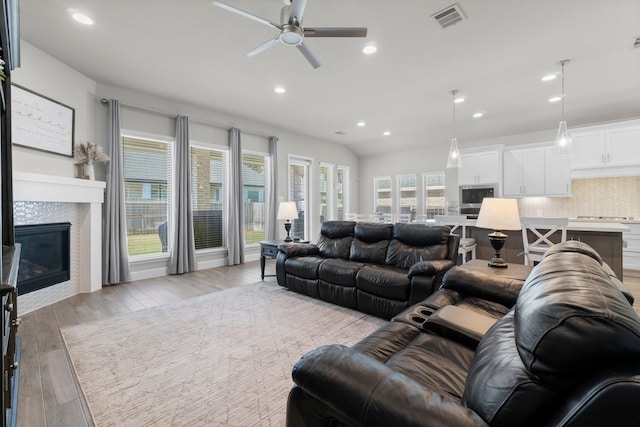 living room featuring light hardwood / wood-style flooring and ceiling fan