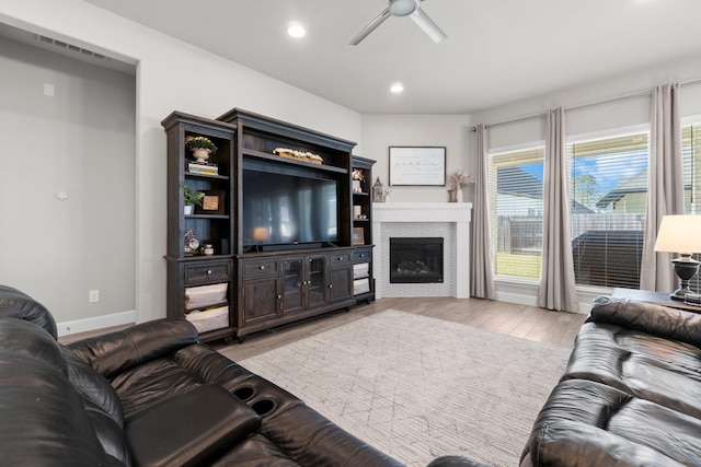 living room with light hardwood / wood-style flooring and ceiling fan