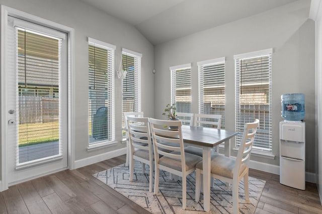 dining area with hardwood / wood-style flooring and vaulted ceiling