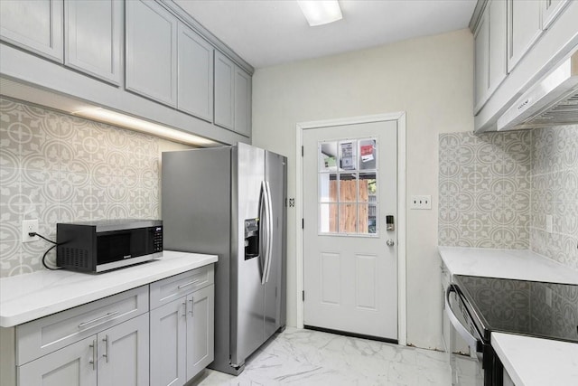 kitchen featuring decorative backsplash, appliances with stainless steel finishes, and gray cabinetry