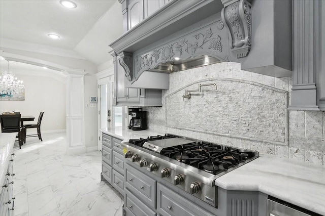 kitchen with stainless steel gas cooktop, vaulted ceiling, gray cabinets, decorative backsplash, and custom exhaust hood