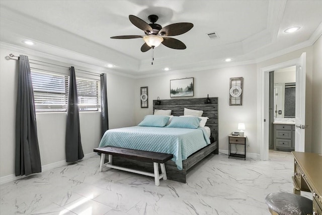 bedroom featuring ceiling fan, a raised ceiling, ornamental molding, and ensuite bathroom