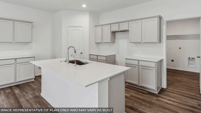 kitchen with a center island with sink, gray cabinets, dark hardwood / wood-style floors, and sink