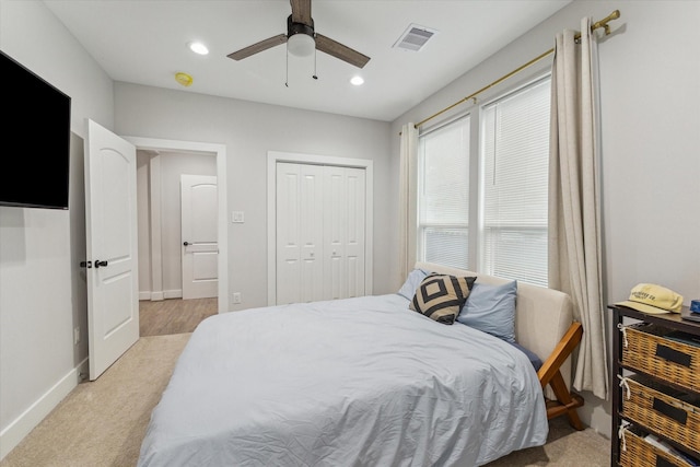 bedroom featuring ceiling fan, light colored carpet, and a closet