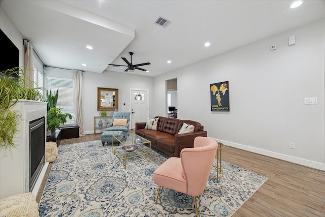 living room with ceiling fan and light hardwood / wood-style flooring