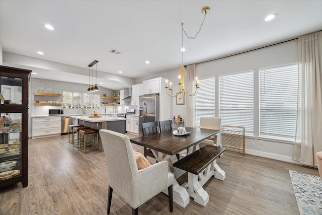 dining area with an inviting chandelier and light hardwood / wood-style flooring