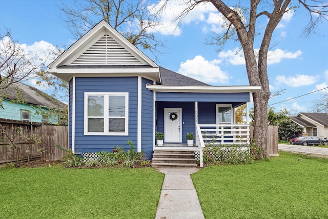 bungalow-style house featuring covered porch and a front yard