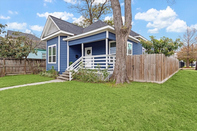 view of front of house featuring covered porch and a front yard