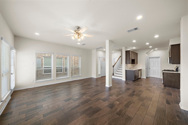 unfurnished living room featuring ceiling fan and dark wood-type flooring