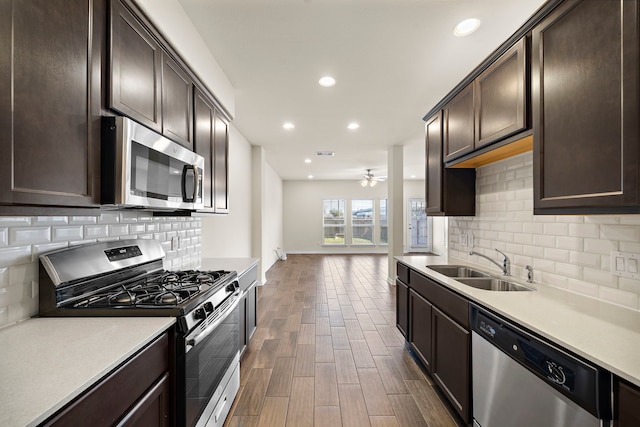 kitchen with sink, ceiling fan, decorative backsplash, dark brown cabinetry, and stainless steel appliances