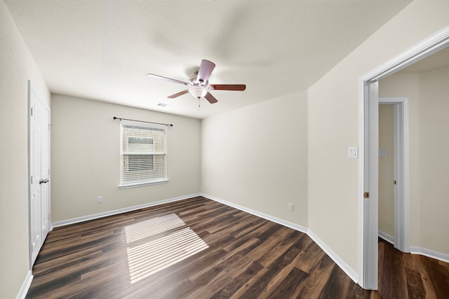 unfurnished room with ceiling fan and dark wood-type flooring