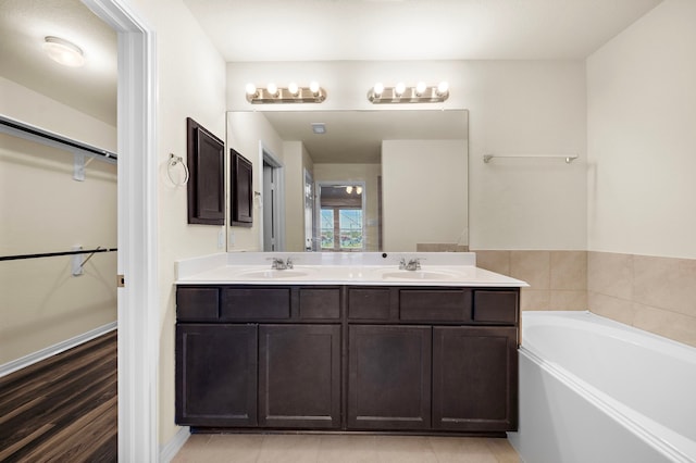 bathroom featuring a bathing tub, tile patterned flooring, and vanity