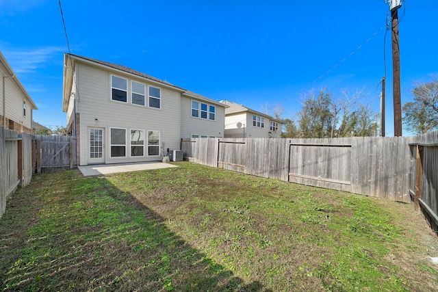 rear view of house with central AC unit, a patio area, and a yard