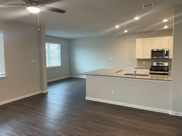 kitchen featuring backsplash, white cabinets, sink, light stone countertops, and stainless steel appliances