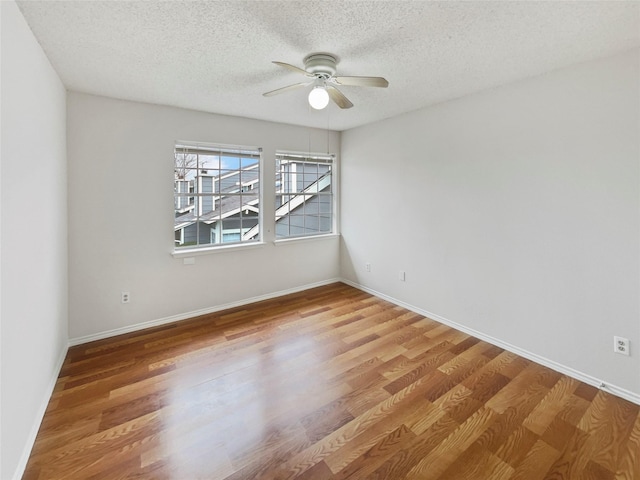 empty room featuring ceiling fan, a textured ceiling, and hardwood / wood-style flooring