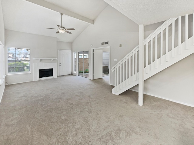 unfurnished living room featuring beamed ceiling, carpet flooring, high vaulted ceiling, and a brick fireplace