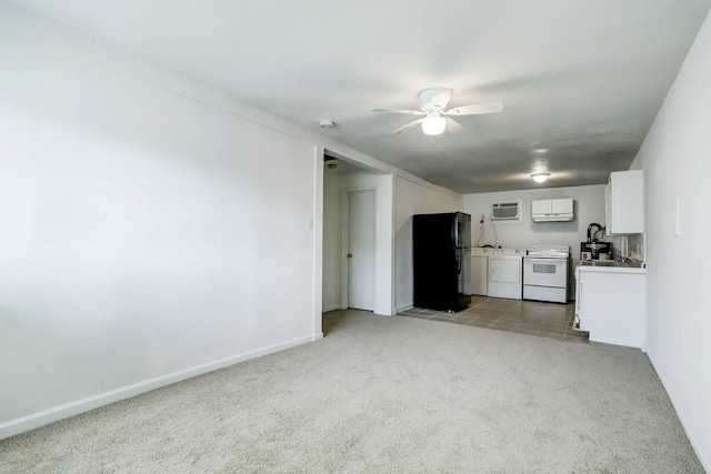 interior space featuring white electric range, black fridge, light colored carpet, white cabinets, and washer and dryer