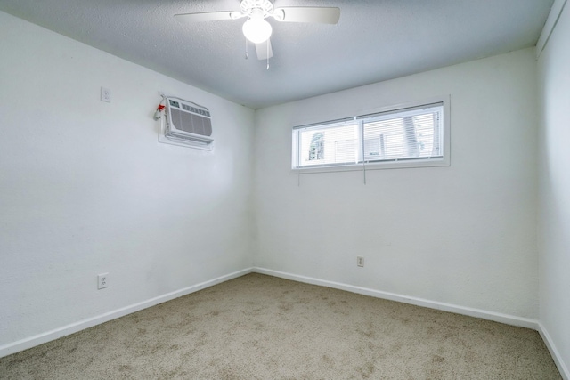 carpeted spare room with ceiling fan and a wall mounted air conditioner