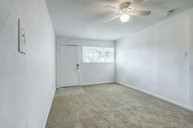 carpeted empty room featuring ceiling fan